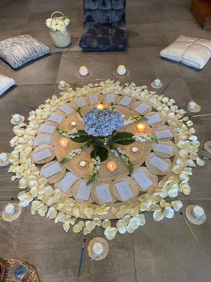 Altar circular con pétalos blancos, flores azules y velas