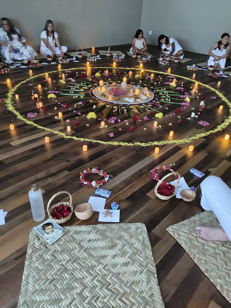 Círculo de participantes alrededor de flores y velas