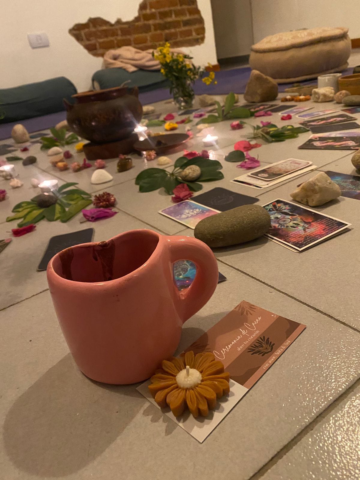 Taza de cacao junto al altar con flores y velas