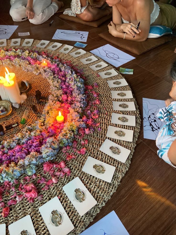 Altar de flores y velas junto a participantes realizando dibujos